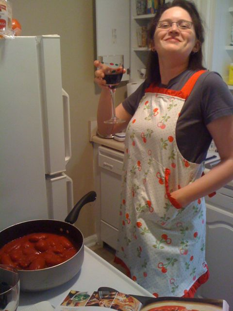 Eliza in her old apartment kitchen, looking smug